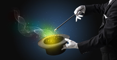Illusionist hand starts to conjure with white glove and magic wand
