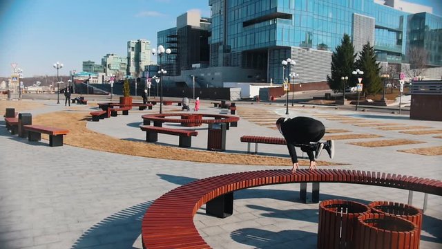 Urban streets. Two men running in the park and overcoming benches