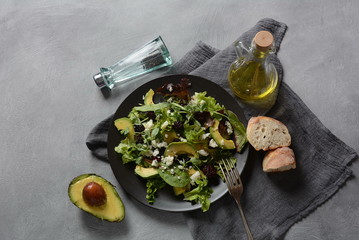Avocado salad with lettuce, blackberry, blue cheese, olive oil and arugula on a plate. Healthy vegan food concept