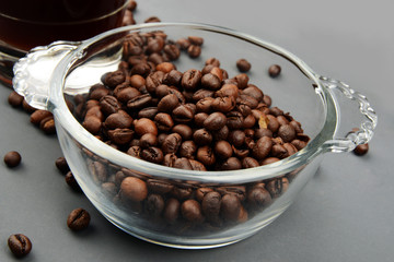 Roasted Coffee beans in a bowl on grey background