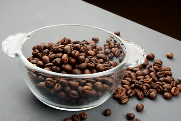 Roasted Coffee beans in a bowl on grey background
