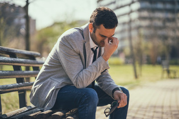 Fototapeta premium Young businessman is very tired. He is relaxing in park. 