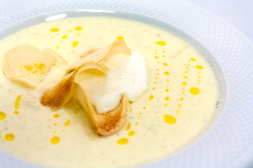 well-done thin slices of croutons in a creamy soup mashed butter in a white plate in a luxurious restaurant