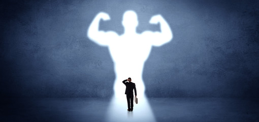 Businessman standing and dreaming about a strong superhero