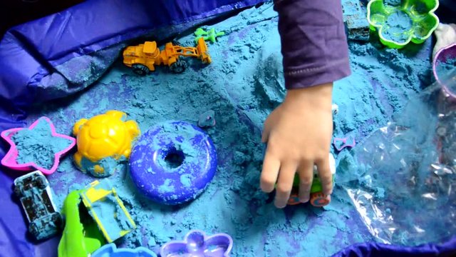 Little boy Playing with Kinetic Sand at Home Early Education Preparing for School Development Children Game. digs sand. carries toys. development of imagination. early development of hand motor