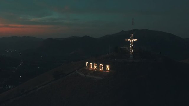 Mount Tapyas with large luminous letters and Christian religious cross at night in Coron city. 15 February - 2019. Busuanga island, Palawan, Philippines.