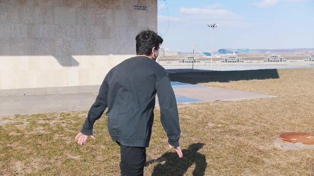 A young man performing acrobatic tricks and flips on the grass