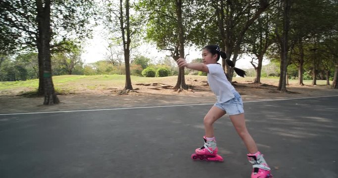Asian little girl playing Roller blade at park.