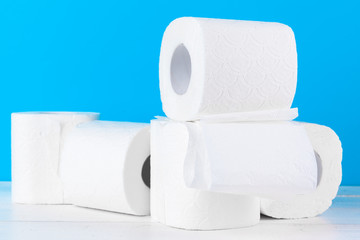 Toilet paper rolls stacked against blue background