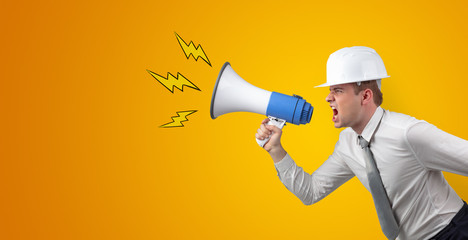 Fototapeta premium Young architect constructor yelling with megaphone and copyspace