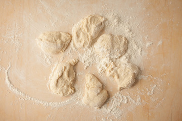 Ball of pizza dough on a rustic wooden background with dusting of flour