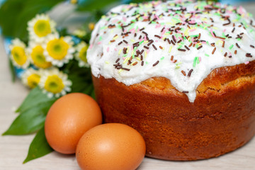 Obraz na płótnie Canvas Easter cake and colored eggs yellow flower blossoms on background. Holiday food and easter concept. Selective focus. Copyspase