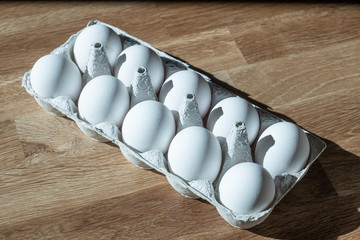 Eierkarton mit 10 Eiern auf Holz