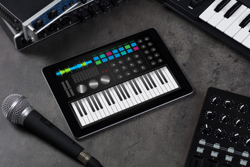 Piano synthesizer app on tablet and musical instrument concept
