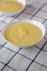 Homemade vanilla custard pudding in a white bowl, side view. Close-up.