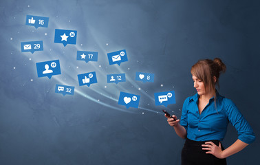 Young person using phone with flying social media icons around
