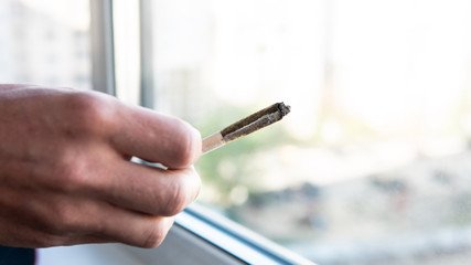 European man smokes joint with marijuana for medical purposes. Cannabis smoking in the world