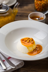 dessert pana cotta with see-buckthorn orange sauce in white plate restaurant