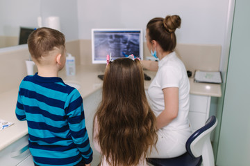 Young patients girl and boy look at the monitor x-ray snapshot