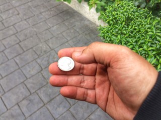 hand with coin on pathway and nature background