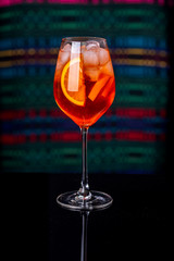 Aperol spritz cocktail in glass on black reflection table in the interior of the restaurant.