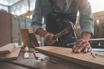 Carpenter working with equipment on wooden table in carpentry shop. woman works in a carpentry shop.