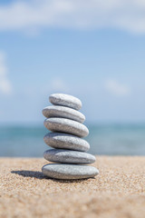 Fototapeta na wymiar stack of pebble stones on balance on a sandy beach