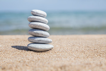 Fototapeta na wymiar stack of pebble stones on balance on a sandy beach