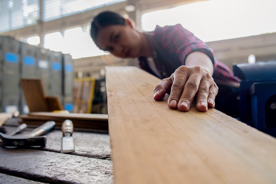 Carpenter working with equipment on wooden table in carpentry shop. woman works in a carpentry shop.