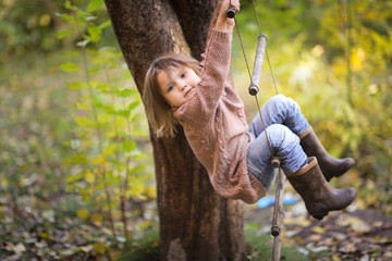 girl child in tree sways on rope ladder © natalialeb