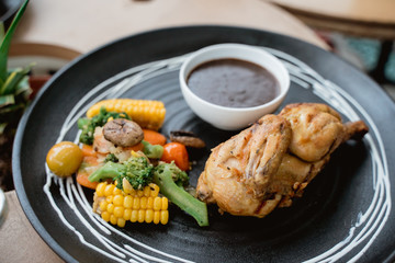 half chicken grill served with mushroom sauce paste and veggie