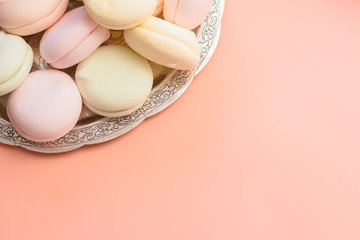Marshmallow on a silver platter, coral  colour background. Copy space for text.