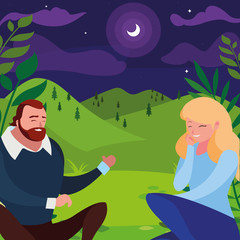 young couple seated in the field at night