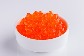 red caviar in a bowl on a white acrylic background