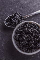 black caviar in a bowl on a dark stone background