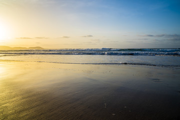Spain, Lanzarote, Perfect golden sunset light reflecting in sand beach of famara