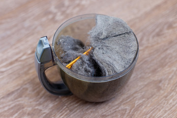 Trash and dust into the plastic cleaner container. Close up
