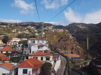 view of the of houses and market gardens of funchal from the cable car running up the mountain to...