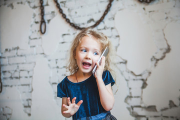 Little girl emotional talking on mobile phone.