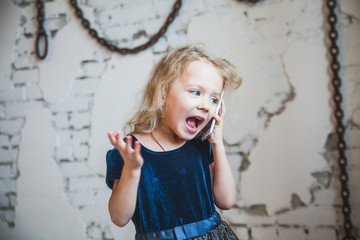 Little girl emotional talking on mobile phone.