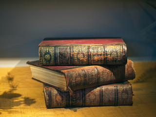 Old vintage stacked books with red and gold leather hardcover.