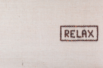 Relax sign made from roasted coffee beans, aligned mid-right on linea texture.