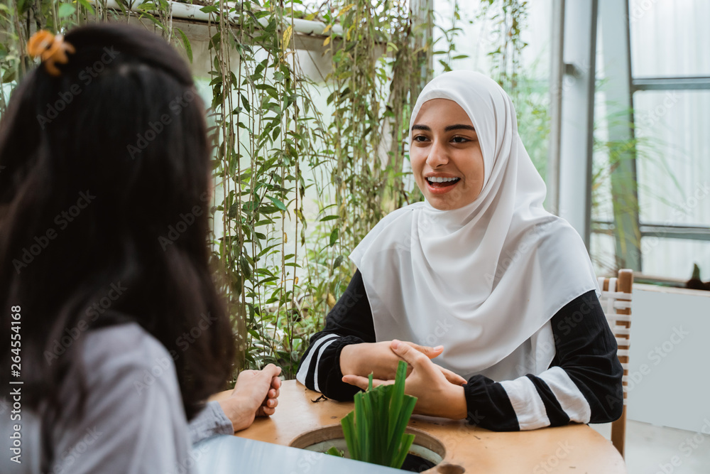 Wall mural beautiful arab muslim woman talk to friend