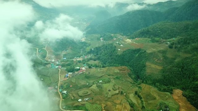 Helicopter top unique view clouds fog cascades terraced rice fields among mountains canyon. Countryside village houses agricultural. Production cultivation culture. Landmark tourism. Asia Vietnam Sapa