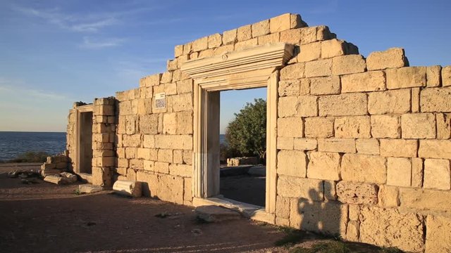 Couple in love photographed and kissing on ruins of Chersonesus basilica, ancient Greek town near modern Sevastopol. Two lovebirds in autumn sunset. UNESCO World Heritage Site. Crimea, Russia.