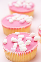 Colorful cupcakes on a pink background.