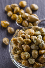 pickled capers on a dark stone background