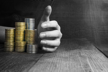 hand picks up piles of money, black and white toning