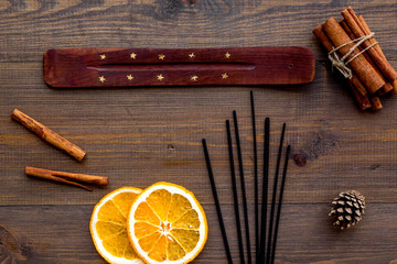Fototapeta na wymiar air freshener sticks with cinnamon and orange on wooden background top view
