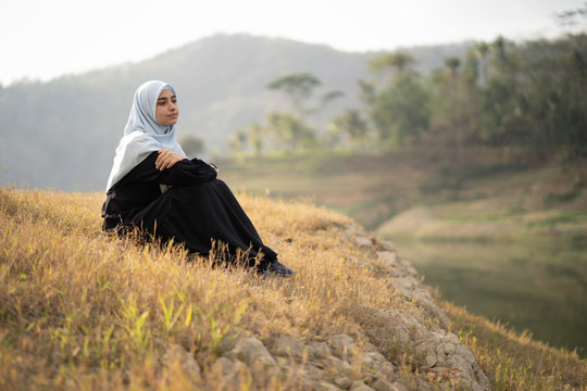 beautiful woman with hijab sitting outdoor enjoy nature in the morning